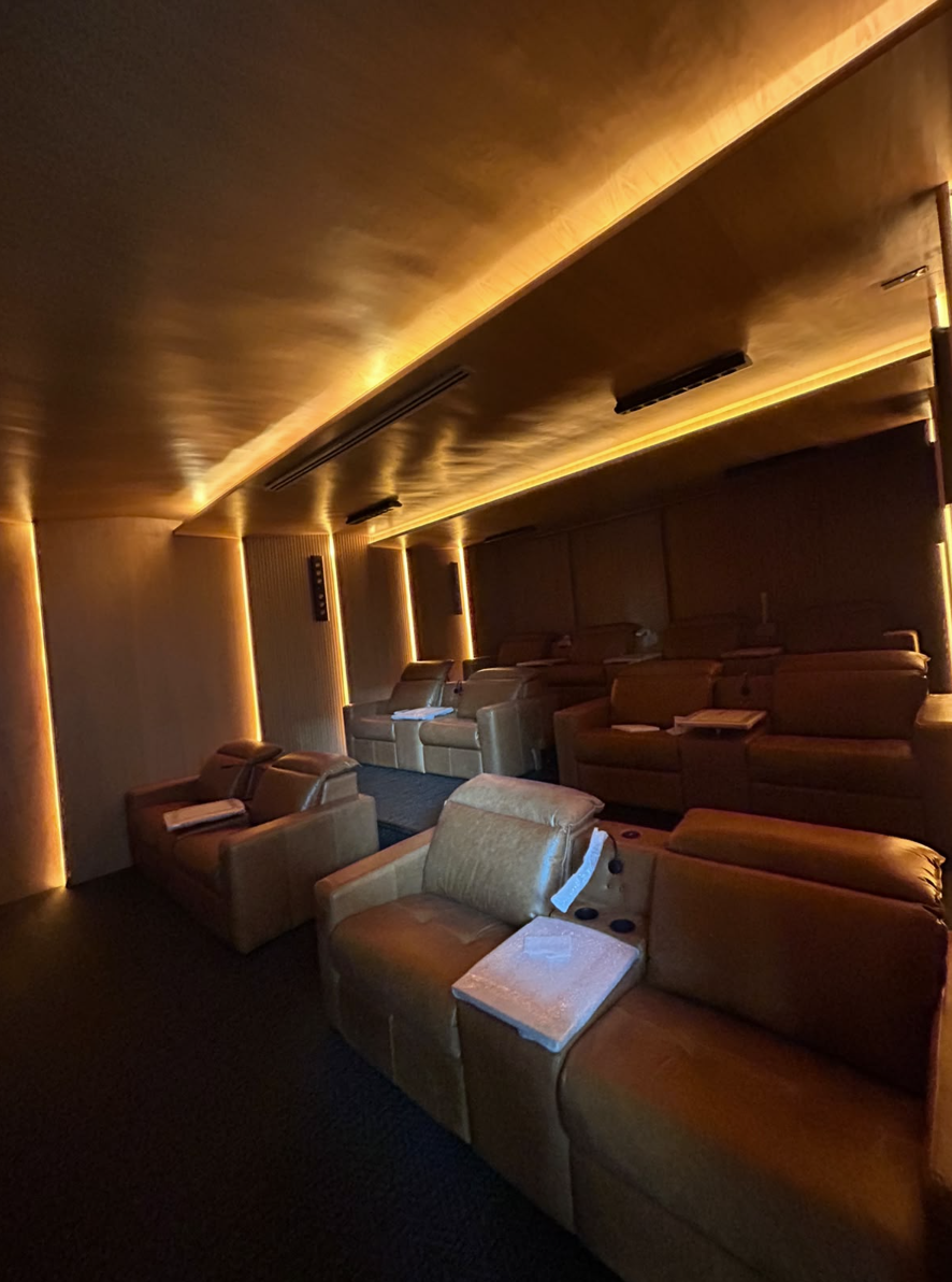 Sala de cinema residencial com iluminação linear indireta