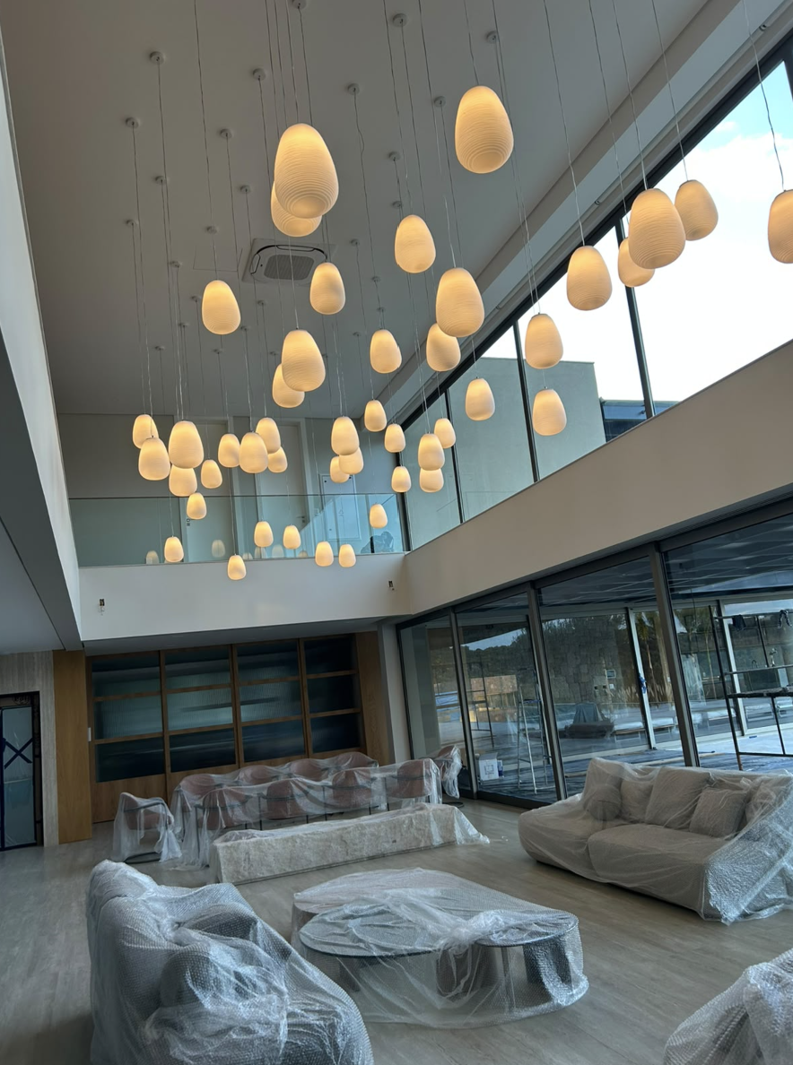 Ambiente interno de pé-direito alto com conjunto de pendentes decorativos