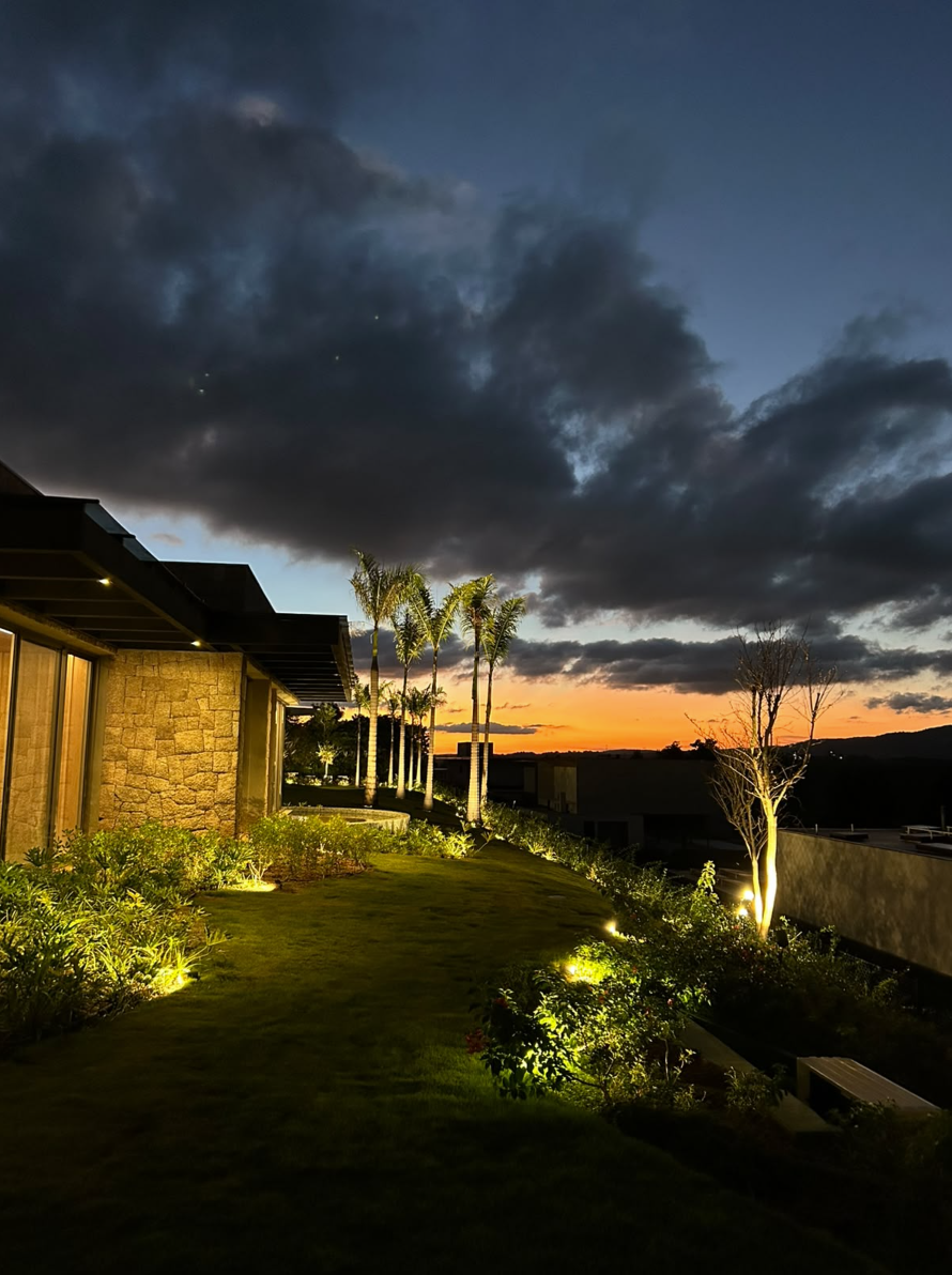 Paisagismo residencial iluminado ao pôr do sol