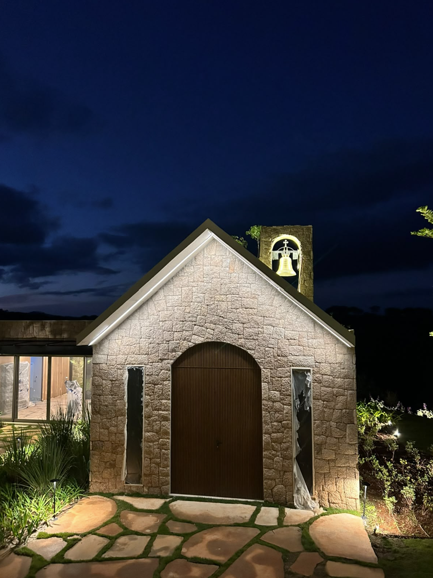 Capela e jardim com iluminação arquitetônica e paisagística